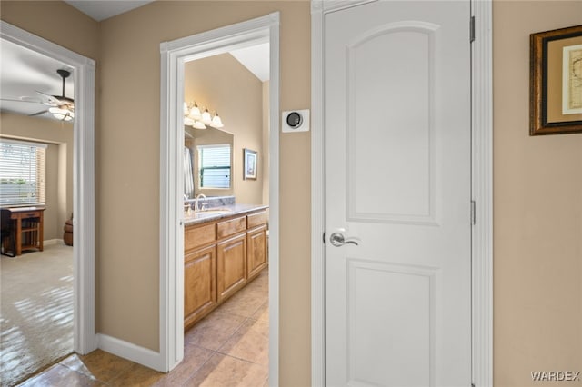 hallway with baseboards and a sink