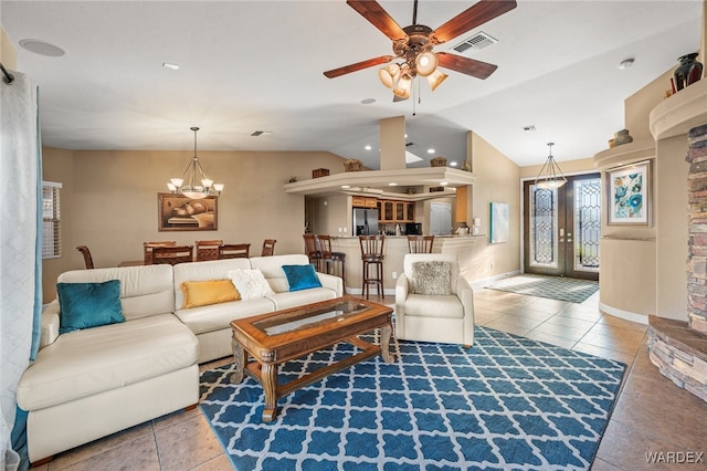 living room with lofted ceiling, light tile patterned floors, ceiling fan with notable chandelier, visible vents, and french doors