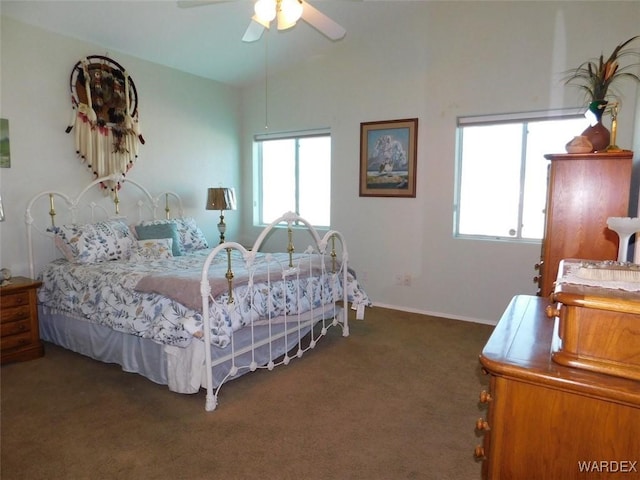 bedroom featuring a ceiling fan, lofted ceiling, multiple windows, and dark carpet