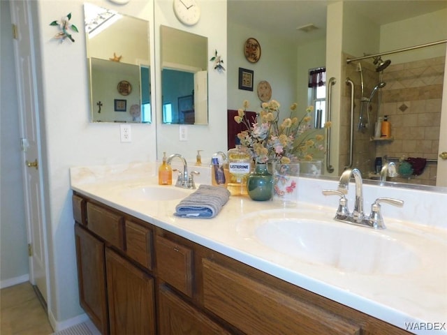 full bathroom with double vanity, tile patterned flooring, walk in shower, and a sink