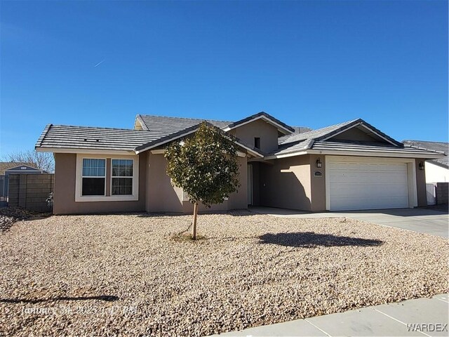 ranch-style house featuring a garage, concrete driveway, and stucco siding