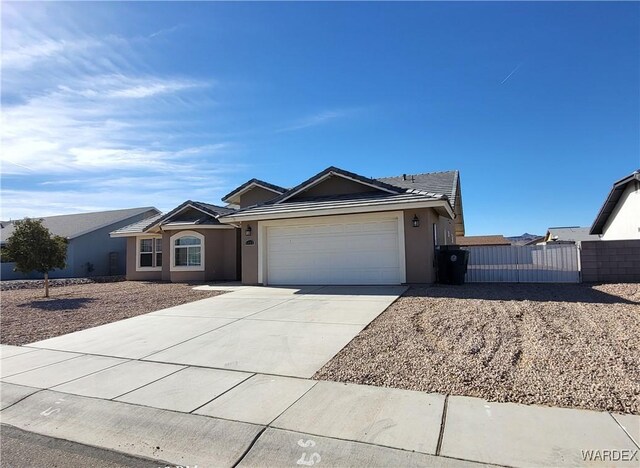 ranch-style home with concrete driveway, an attached garage, and stucco siding