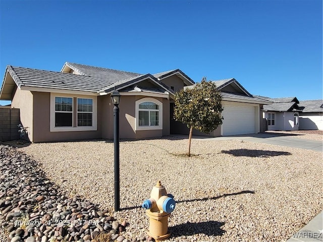 single story home featuring a tile roof, driveway, an attached garage, and stucco siding