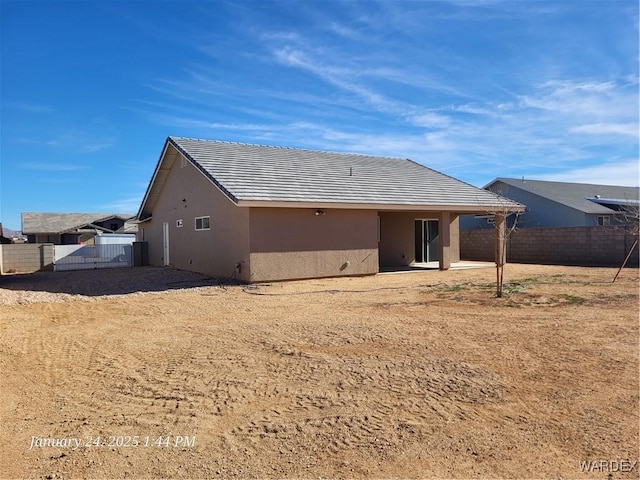 rear view of property with fence and stucco siding