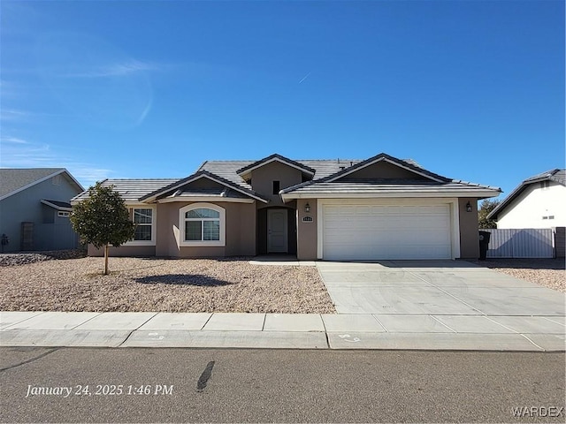 single story home featuring a garage, concrete driveway, a tile roof, and stucco siding