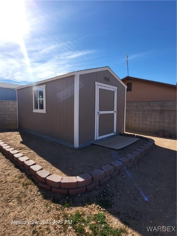 view of shed featuring fence