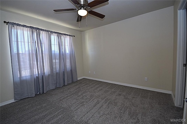 unfurnished room featuring a ceiling fan, dark colored carpet, and baseboards