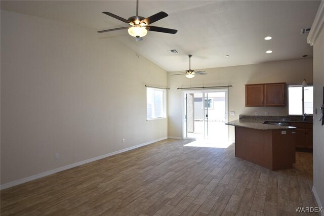 kitchen featuring open floor plan, dark wood-type flooring, dark countertops, and baseboards