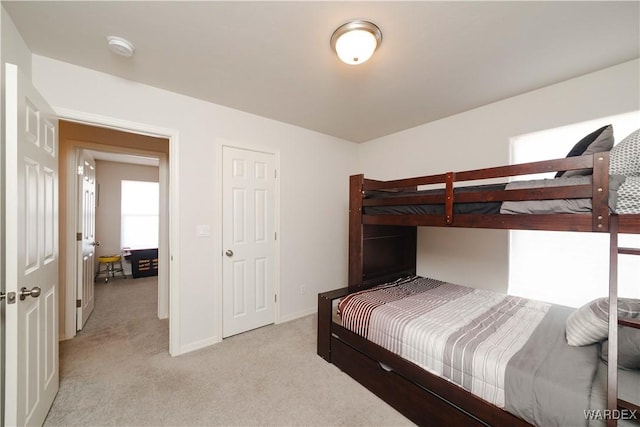 bedroom featuring light colored carpet and baseboards