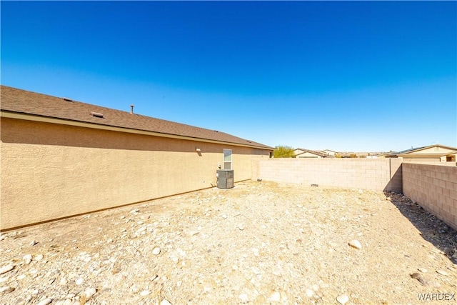 view of yard featuring a fenced backyard and central AC unit