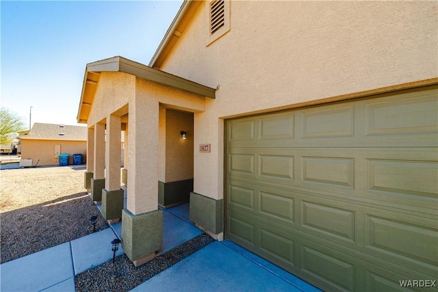 property entrance featuring a garage and stucco siding