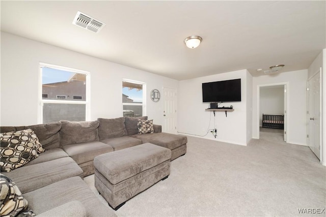 living room featuring visible vents, light carpet, and baseboards