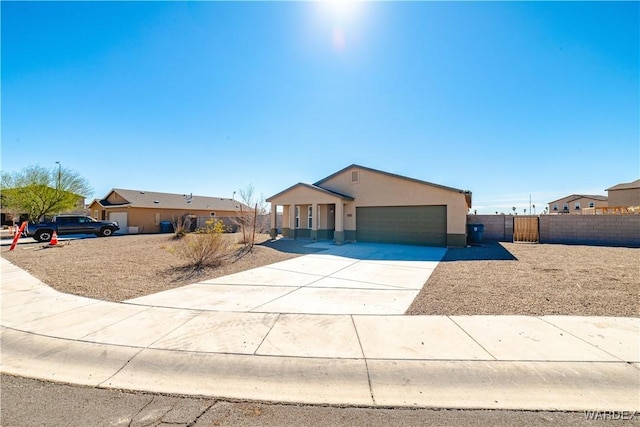 view of front of property featuring an attached garage, fence, driveway, a gate, and stucco siding