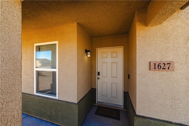 property entrance with stucco siding