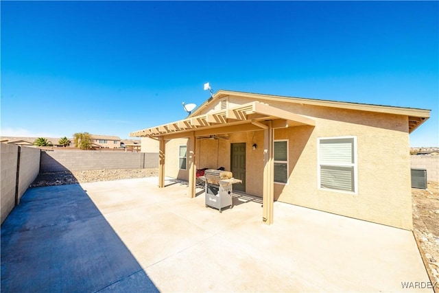 back of house with a ceiling fan, a patio area, a fenced backyard, and stucco siding