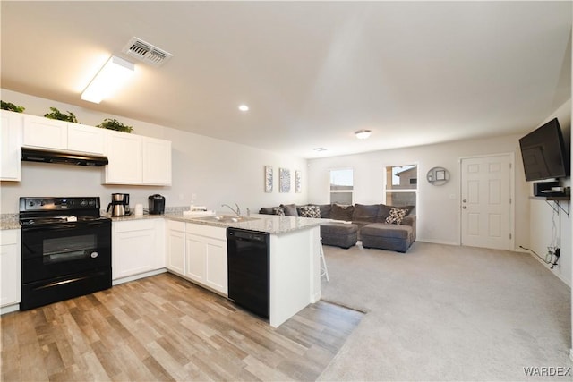 kitchen featuring under cabinet range hood, a sink, visible vents, open floor plan, and black appliances