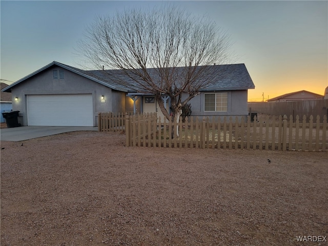 ranch-style house featuring a garage, concrete driveway, a fenced front yard, and stucco siding