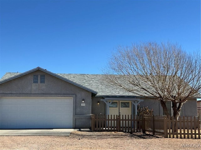 single story home featuring a fenced front yard, roof with shingles, stucco siding, an attached garage, and driveway