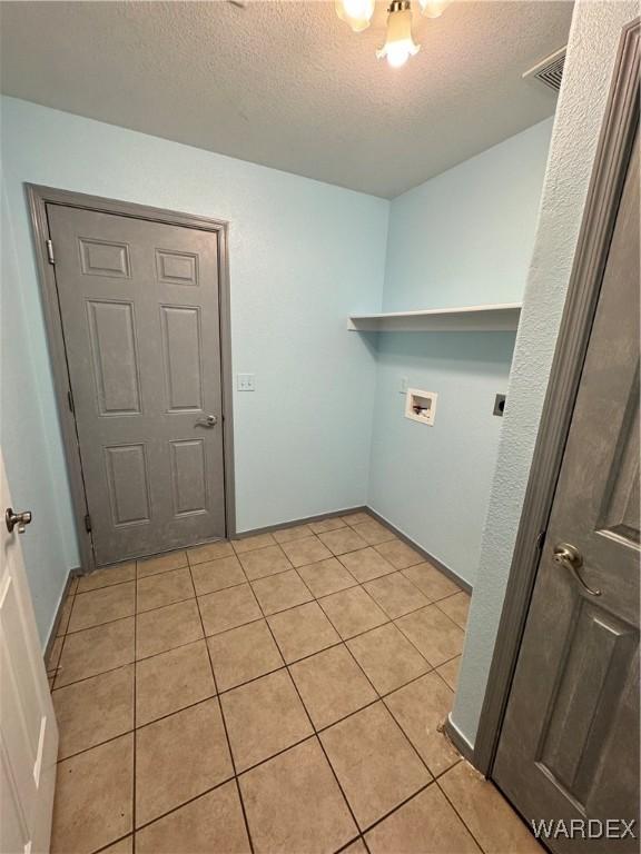 laundry area with light tile patterned floors, laundry area, washer hookup, and electric dryer hookup