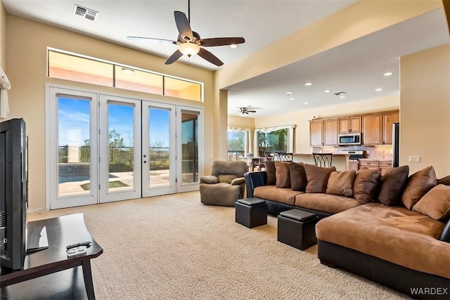 living room featuring a ceiling fan, visible vents, recessed lighting, french doors, and carpet flooring