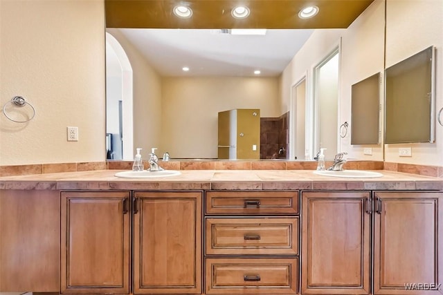 bathroom with a sink, recessed lighting, and double vanity