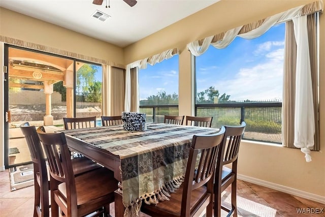 tiled dining space featuring visible vents, baseboards, and ceiling fan