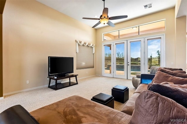 living room with visible vents, carpet floors, baseboards, and ceiling fan