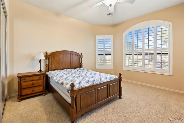 bedroom featuring visible vents, light colored carpet, baseboards, and ceiling fan