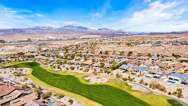 drone / aerial view with view of golf course, a mountain view, and a residential view