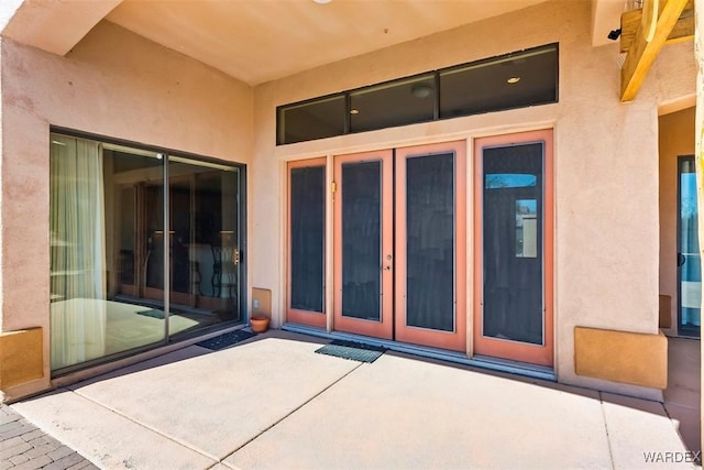 doorway to property with a patio area, stucco siding, and french doors