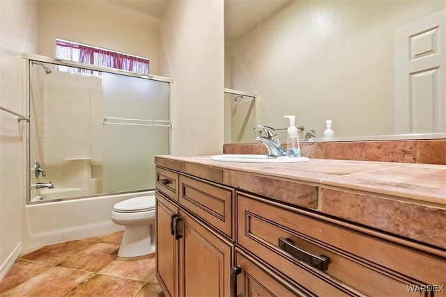 full bath with tile patterned flooring, combined bath / shower with glass door, toilet, and vanity