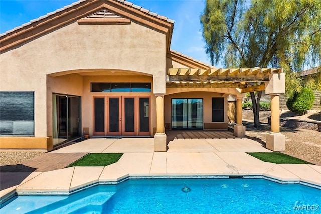 rear view of house with stucco siding, a patio, and a tile roof