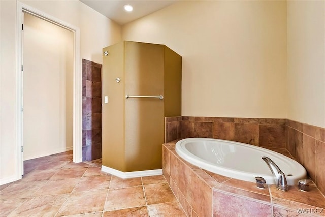 full bathroom with tile patterned flooring, a garden tub, a walk in shower, and baseboards