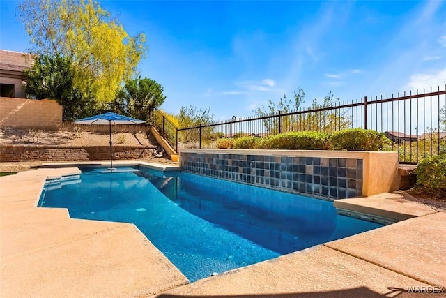 pool with a fenced backyard and a patio area