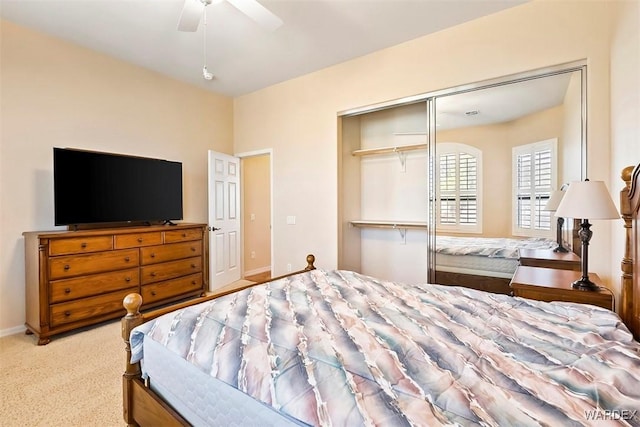 carpeted bedroom featuring a closet, baseboards, and a ceiling fan