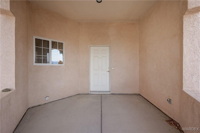 entrance to property with a patio area and stucco siding