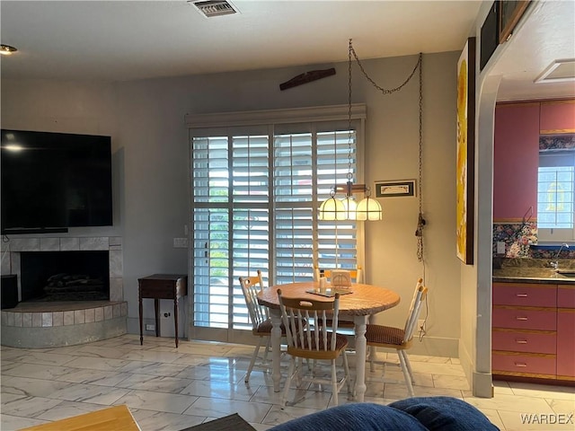 211 Columbine Dr, Lake Havasu, AZ 86403 - dining area with a fireplace with raised hearth, visible vents, and marble finish floor