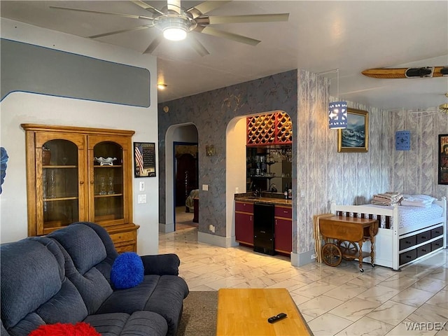 211 Columbine Dr, Lake Havasu, AZ 86403 - living room featuring ceiling fan, arched walkways, marble finish floor, wallpapered walls, and indoor bar