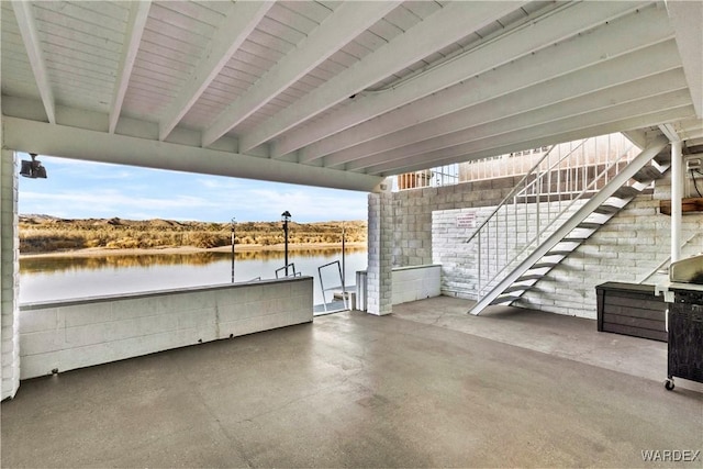 view of patio / terrace with stairs and a water view