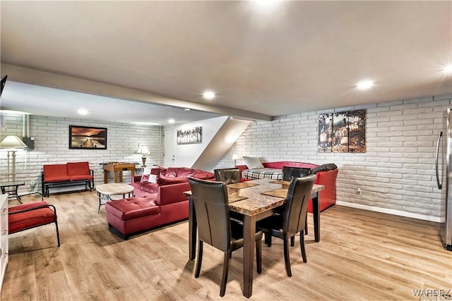 dining area with light wood finished floors, brick wall, and recessed lighting