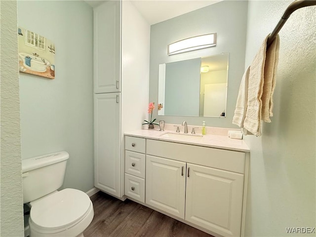 bathroom featuring vanity, toilet, and wood finished floors