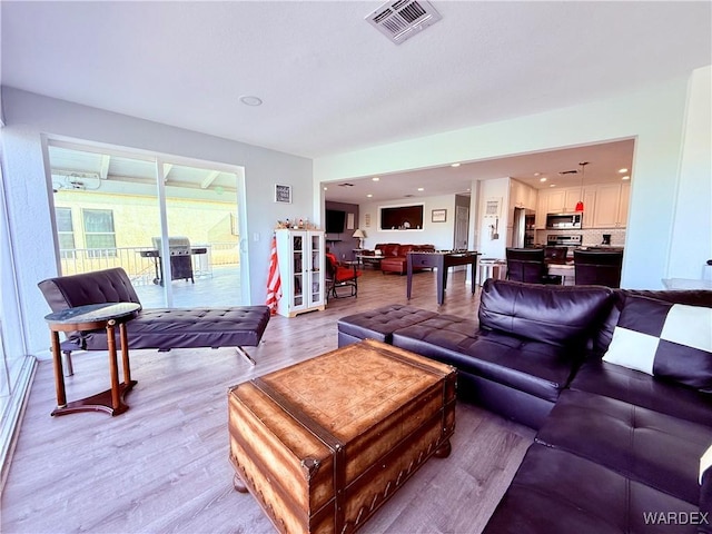 living area featuring light wood-type flooring, visible vents, and recessed lighting