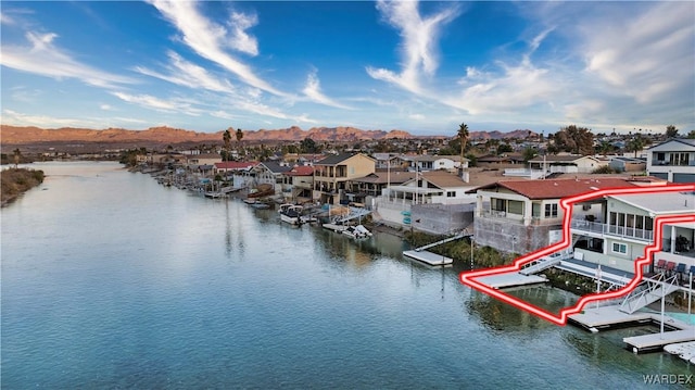 water view featuring a dock, a residential view, and a mountain view