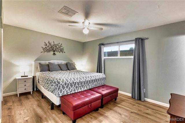 bedroom featuring light wood-style flooring, a ceiling fan, visible vents, and baseboards