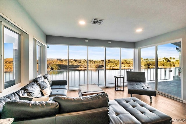 sunroom / solarium with a water view and visible vents