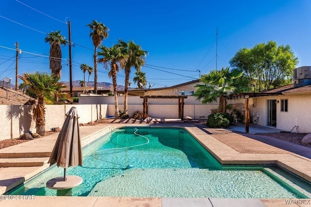 view of swimming pool with a patio area, a fenced backyard, cooling unit, and a fenced in pool