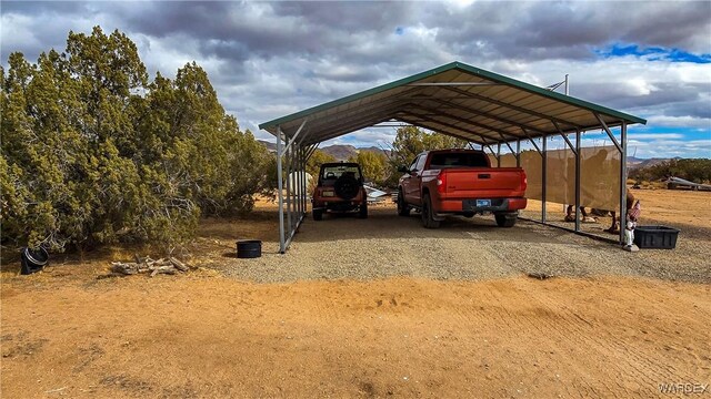 view of vehicle parking featuring dirt driveway and a detached carport