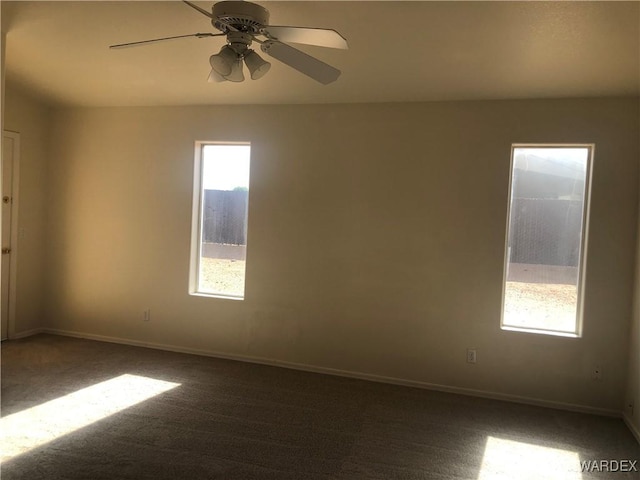 carpeted empty room with baseboards and a ceiling fan