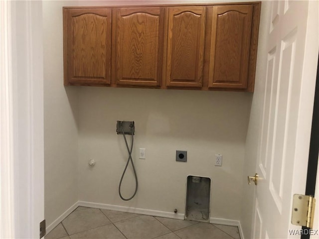 laundry area featuring cabinet space, light tile patterned floors, hookup for an electric dryer, and gas dryer hookup