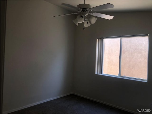 spare room featuring ceiling fan, baseboards, and dark colored carpet